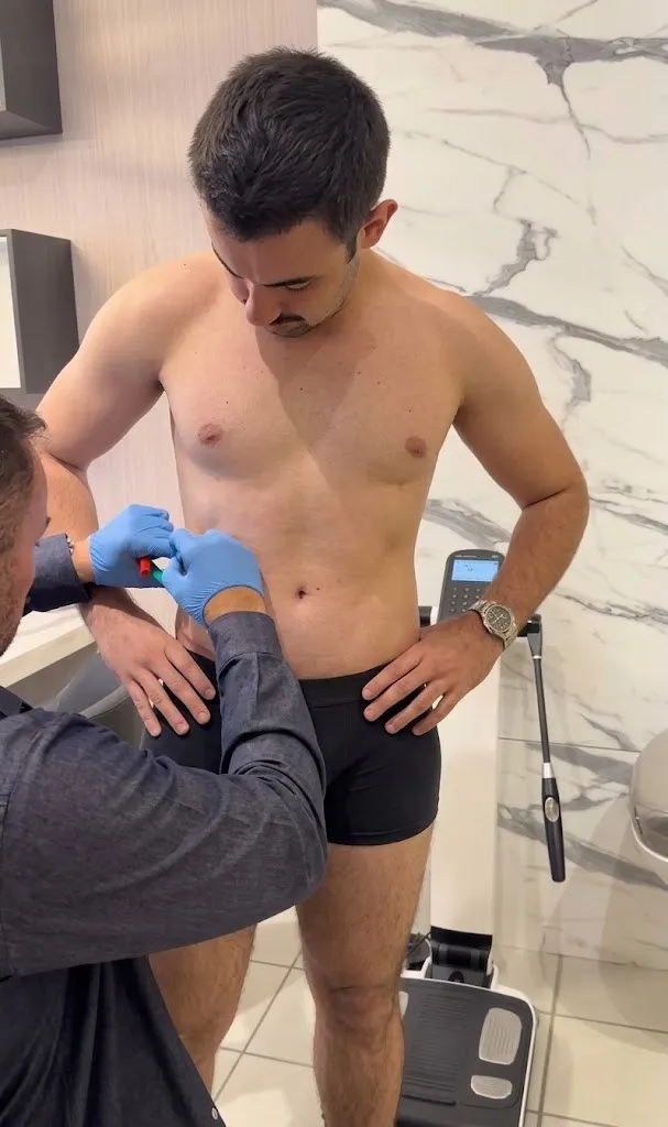 Dr. Jorge de luvas realizando um procedimento no abdômen de um paciente